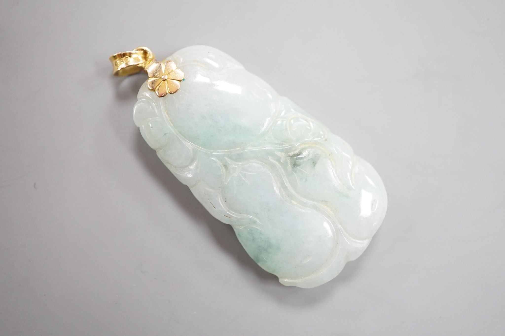 A modern 14k mounted jade plaque, carved with fruit, 44mm, gross weight 17.3 grams.